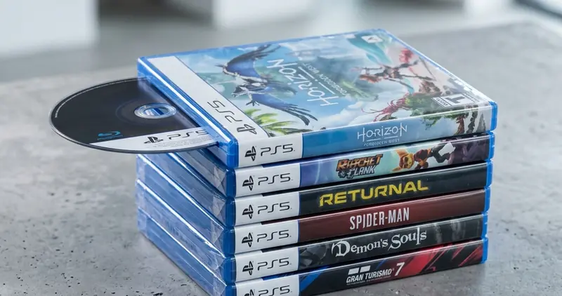 PlayStation 5 遊戲光碟盒與藍光光碟片堆疊在桌面上，代表實體光碟即將走入歷史